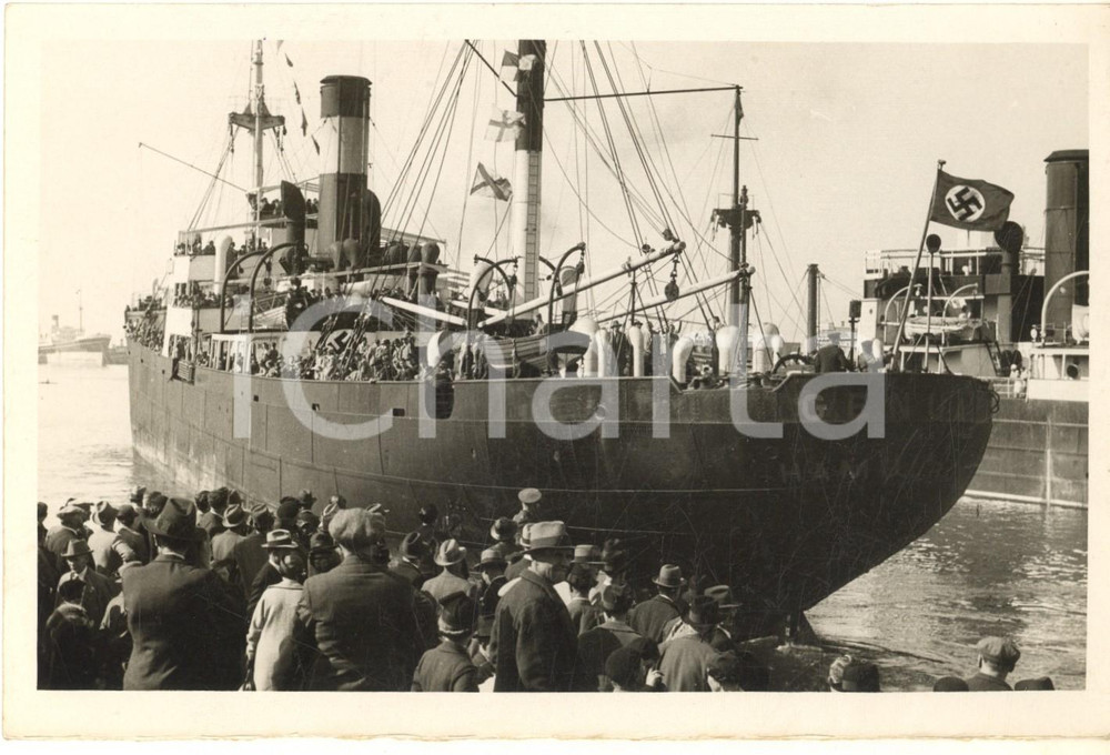 1936 GENOVA Partenza dei tedeschi residenti in Italia sulla nave GENUA *Foto (1)  Fotografia originale d'epoca, con timbro datario e didascalia dattiloscritta:"I tedeschi residenti in Liguria, Piemonte e Lombardia si sono oggi imbarcati sul Genua, il quale li porterà fuori delle acque territoriali, ove gli elettori imbarcati voteranno". POOR/danneggiato margine inferiore rifilato Formato: 18x13 cm originale e autentica 1
