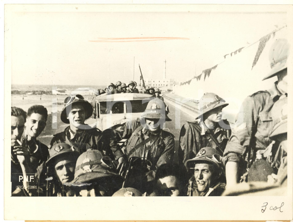 1941 WW2 NORD AFRICA Arrivo dei volontari universitari del PNF *Foto 24x18 cm  Fotografia originale d'epoca, con didascalia dattiloscritta. POOR/danneggiato segno centrale a pastello; residui cartacei; piccolo strappo alla didascalia Formato: 24x18 cm originale e autentica 1