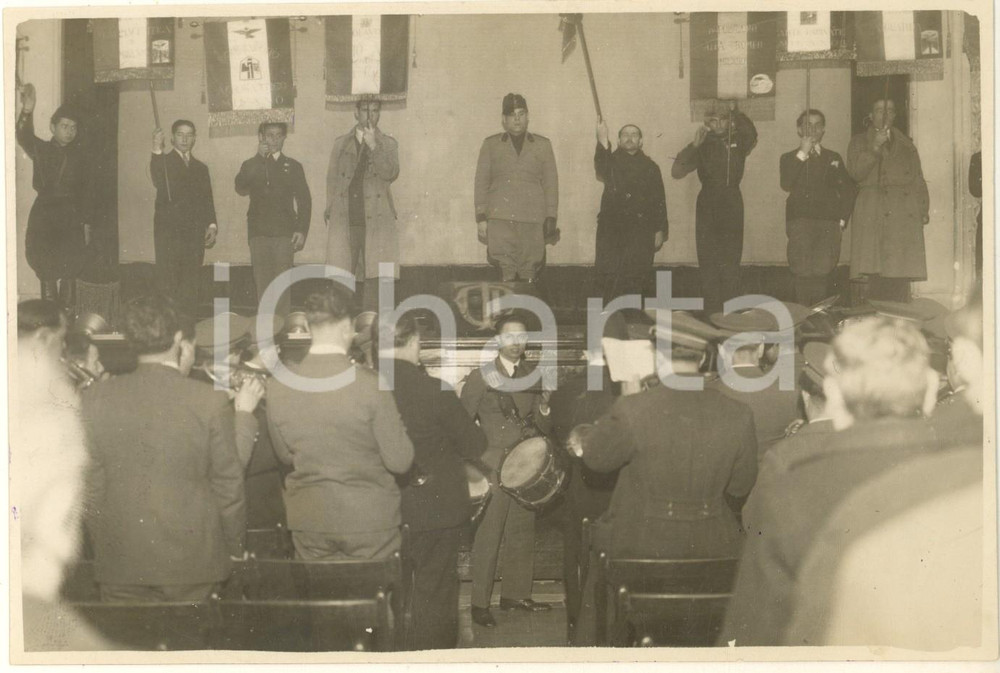 1932 MILANO Cine-Teatro ITALIA - Commemorazione Caduti di BOLAMA *Foto 17x12 cm  Fotografia originale d'epoca, con timbro datario e didascalia manoscritta al verso che cita le autorità presenti: Amedeo Paolaccim Ugo Conti, il gen. Guido Tacchini, i colonnelli Gallotti, Biagini, Leveratto e Germano, e il magg. De Angeli.Si tratta di una cerimonia voluta dall'OND Aeronautica in ricordo dei Caduti di Bolama (tragico evento della Crociera transatlantica Italia-Brasile del 1931, dove morirono 5 aviatori). FAIR/discreto graffio al lato superiore; minimi difetti di stampa Formato: 17x12 cm originale e autentica 1