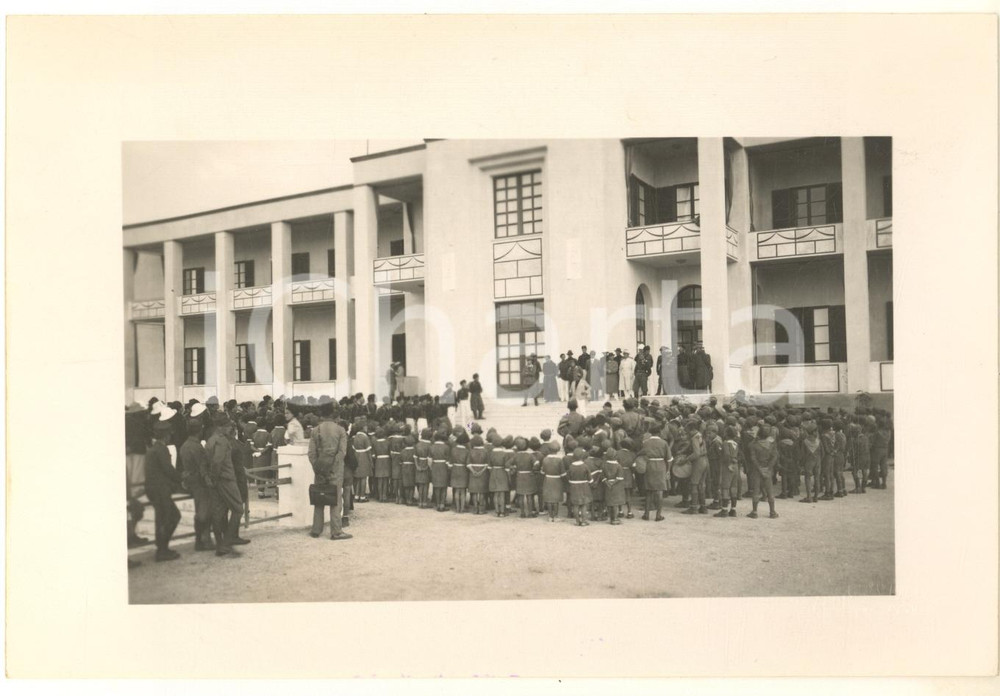 1933 LIBIA - CIRENE Grande Albergo - Discorso ai Giovani Fascisti dell'Urbe  Fotografia originale d'epoca, con timbro datario e didascalia dattiloscritta al verso:"Il Comandante del Campeggio Gebelico parla ai Giovani Fascisti dell'Urbe riuniti davanti al Grande Albergo di Cirene". GOOD/buono  Formato: 17x12 cm originale e autentica 1