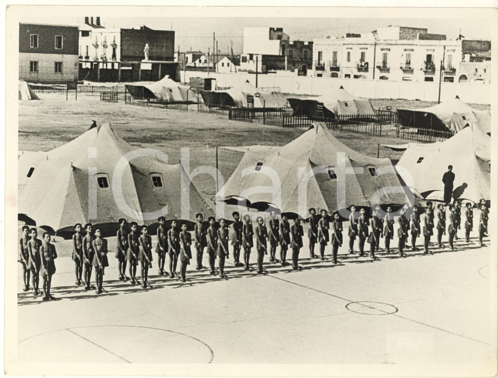 1942 FASCISMO ITALIA Un campeggio della G.I.L. - Foto 24x18 cm  Fotografia originale d'epoca, con timbro datario e didascalia dattiloscritta al verso. FAIR/discreto lievi piegature marginali; piegatura angolare Formato: 24x18 cm originale e autentica 1