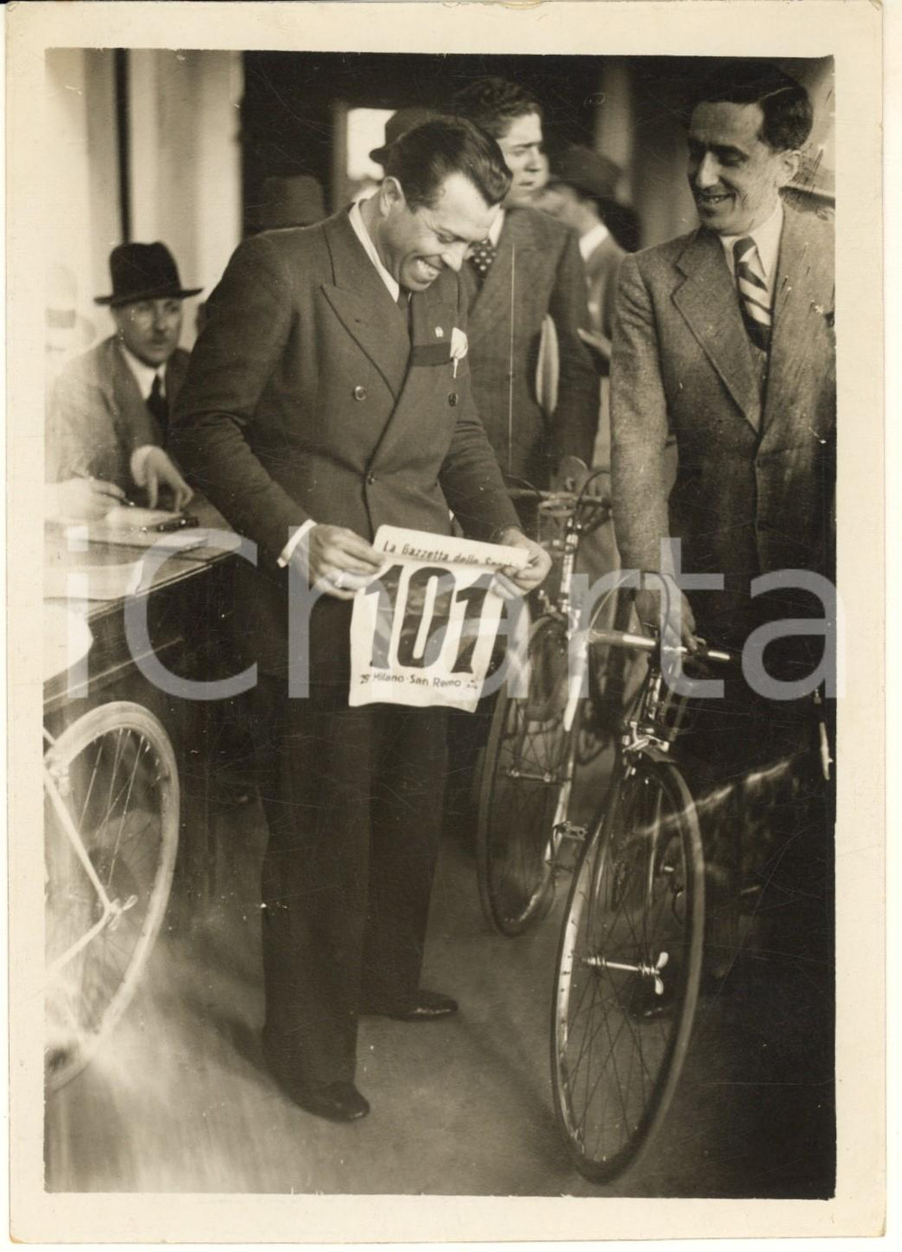 1937 CICLISMO MILANO-SANREMO Learco GUERRA ritira il proprio numero *Foto Fotografia originale d'epoca, con timbro datario e didascalia al verso. FAIR/discreto difetti di stampa e graffi Formato: 13x18 cm originale e autentica 1