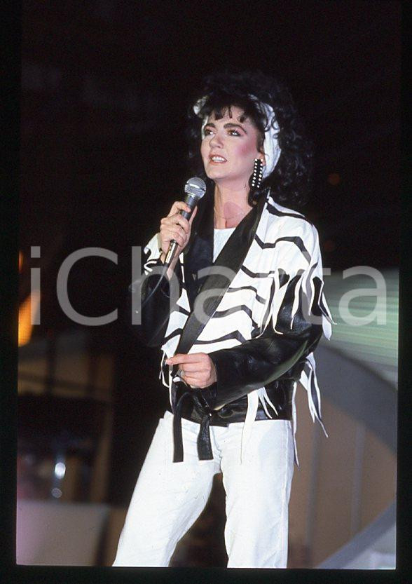 1985 ca ITALIA - MUSICA Marina FIORDALISO Concerto - 35 mm vintage slide (1) Diapositiva d'epoca, in formato 35 mm.CONDIZIONI: GOODE' severamente vietata la riproduzione. Tutti i diritti sono riservati.Nella diapositiva ICharta mette in vendita, sul negozio eBay e in esclusiva sul sito "icharta" il proprio archivio composto da numerose diapositive e negativi fotografici d'epoca, tutti originali e autentici, che attraversano la storia del costume italiano tra gli la fine degli anni Sessanta e Novanta.Si tratta di uno sguardo inedito sull'attualità , la politica, la vita quotidiana, il gossip e la cultura, che fotografa il cambiamento della nazione in quest'ultimo scorcio del XX secolo. Un'occasione unica per il mercato del collezionismo, che vede finalmente disponibile un archivio eccezionale per vastità , tematiche e condizioni, in un settore (il negativo fotografico e la diapositiva) di assoluta novità e dalle interessanti prospettive di investimento.  GOOD/buono   originale e autentica 1