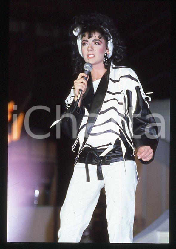 1985 ca ITALIA - MUSICA Marina FIORDALISO Concerto - 35 mm vintage slide Diapositiva d'epoca, in formato 35 mm.CONDIZIONI: GOODE' severamente vietata la riproduzione. Tutti i diritti sono riservati.Nella diapositiva ICharta mette in vendita, sul negozio eBay e in esclusiva sul sito "icharta" il proprio archivio composto da numerose diapositive e negativi fotografici d'epoca, tutti originali e autentici, che attraversano la storia del costume italiano tra gli la fine degli anni Sessanta e Novanta.Si tratta di uno sguardo inedito sull'attualità , la politica, la vita quotidiana, il gossip e la cultura, che fotografa il cambiamento della nazione in quest'ultimo scorcio del XX secolo. Un'occasione unica per il mercato del collezionismo, che vede finalmente disponibile un archivio eccezionale per vastità , tematiche e condizioni, in un settore (il negativo fotografico e la diapositiva) di assoluta novità e dalle interessanti prospettive di investimento.  GOOD/buono   originale e autentica 1