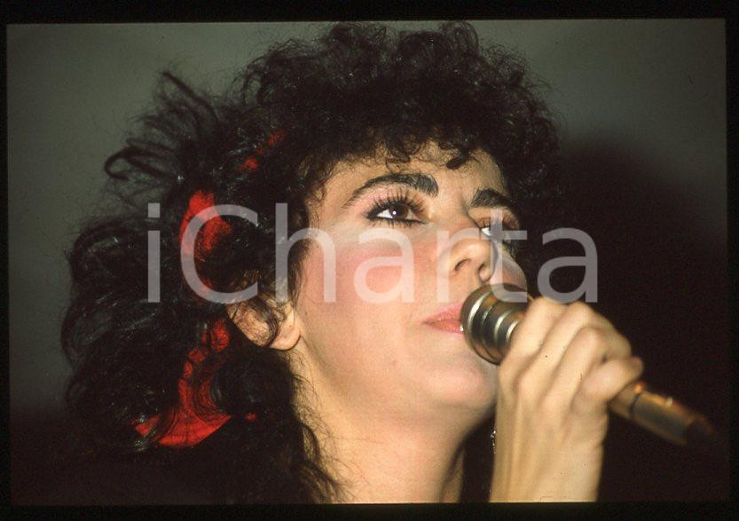 1985 ca ITALIA - MUSICA Marina FIORDALISO Concerto - 35 mm vintage slide (4) Diapositiva d'epoca, in formato 35 mm.CONDIZIONI: GOODE' severamente vietata la riproduzione. Tutti i diritti sono riservati.Nella diapositiva ICharta mette in vendita, sul negozio eBay e in esclusiva sul sito "icharta" il proprio archivio composto da numerose diapositive e negativi fotografici d'epoca, tutti originali e autentici, che attraversano la storia del costume italiano tra gli la fine degli anni Sessanta e Novanta.Si tratta di uno sguardo inedito sull'attualità , la politica, la vita quotidiana, il gossip e la cultura, che fotografa il cambiamento della nazione in quest'ultimo scorcio del XX secolo. Un'occasione unica per il mercato del collezionismo, che vede finalmente disponibile un archivio eccezionale per vastità , tematiche e condizioni, in un settore (il negativo fotografico e la diapositiva) di assoluta novità e dalle interessanti prospettive di investimento.  GOOD/buono   originale e autentica 1