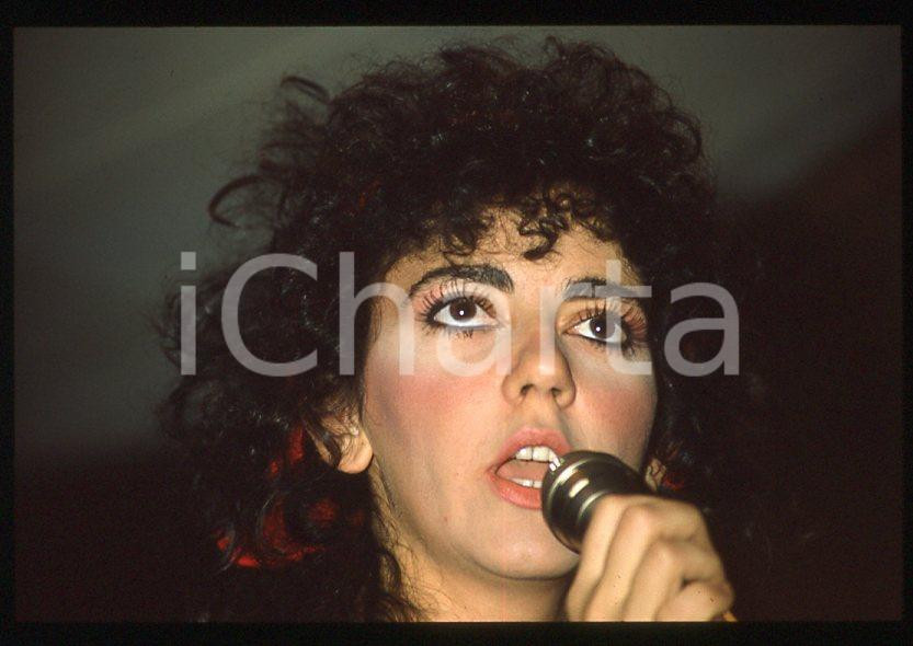 1985 ca ITALIA - MUSICA Marina FIORDALISO Concerto - 35 mm vintage slide (8) Diapositiva d'epoca, in formato 35 mm.CONDIZIONI: GOODE' severamente vietata la riproduzione. Tutti i diritti sono riservati.Nella diapositiva ICharta mette in vendita, sul negozio eBay e in esclusiva sul sito "icharta" il proprio archivio composto da numerose diapositive e negativi fotografici d'epoca, tutti originali e autentici, che attraversano la storia del costume italiano tra gli la fine degli anni Sessanta e Novanta.Si tratta di uno sguardo inedito sull'attualità , la politica, la vita quotidiana, il gossip e la cultura, che fotografa il cambiamento della nazione in quest'ultimo scorcio del XX secolo. Un'occasione unica per il mercato del collezionismo, che vede finalmente disponibile un archivio eccezionale per vastità , tematiche e condizioni, in un settore (il negativo fotografico e la diapositiva) di assoluta novità e dalle interessanti prospettive di investimento.  GOOD/buono   originale e autentica 1