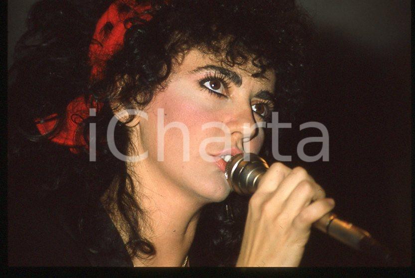 1985 ca ITALIA - MUSICA Marina FIORDALISO Concerto - 35 mm vintage slide (7) Diapositiva d'epoca, in formato 35 mm.CONDIZIONI: GOODE' severamente vietata la riproduzione. Tutti i diritti sono riservati.Nella diapositiva ICharta mette in vendita, sul negozio eBay e in esclusiva sul sito "icharta" il proprio archivio composto da numerose diapositive e negativi fotografici d'epoca, tutti originali e autentici, che attraversano la storia del costume italiano tra gli la fine degli anni Sessanta e Novanta.Si tratta di uno sguardo inedito sull'attualità , la politica, la vita quotidiana, il gossip e la cultura, che fotografa il cambiamento della nazione in quest'ultimo scorcio del XX secolo. Un'occasione unica per il mercato del collezionismo, che vede finalmente disponibile un archivio eccezionale per vastità , tematiche e condizioni, in un settore (il negativo fotografico e la diapositiva) di assoluta novità e dalle interessanti prospettive di investimento.  GOOD/buono   originale e autentica 1