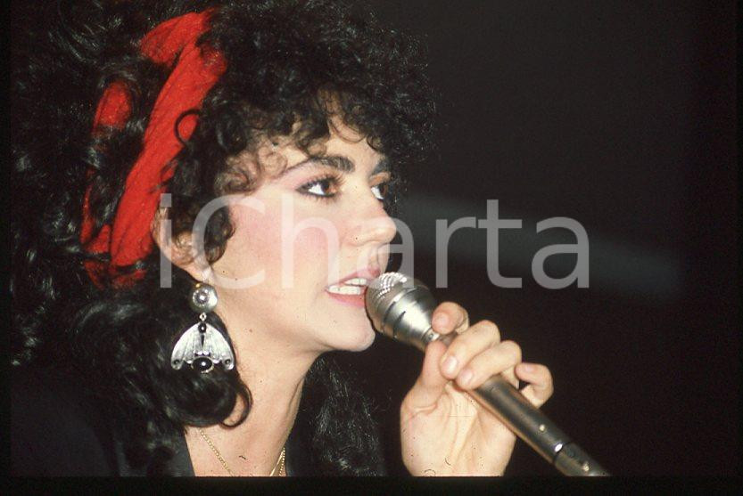 1985 ca ITALIA - MUSICA Marina FIORDALISO Concerto - 35 mm vintage slide (9) Diapositiva d'epoca, in formato 35 mm.CONDIZIONI: GOODE' severamente vietata la riproduzione. Tutti i diritti sono riservati.Nella diapositiva ICharta mette in vendita, sul negozio eBay e in esclusiva sul sito "icharta" il proprio archivio composto da numerose diapositive e negativi fotografici d'epoca, tutti originali e autentici, che attraversano la storia del costume italiano tra gli la fine degli anni Sessanta e Novanta.Si tratta di uno sguardo inedito sull'attualità , la politica, la vita quotidiana, il gossip e la cultura, che fotografa il cambiamento della nazione in quest'ultimo scorcio del XX secolo. Un'occasione unica per il mercato del collezionismo, che vede finalmente disponibile un archivio eccezionale per vastità , tematiche e condizioni, in un settore (il negativo fotografico e la diapositiva) di assoluta novità e dalle interessanti prospettive di investimento.  GOOD/buono   originale e autentica 1