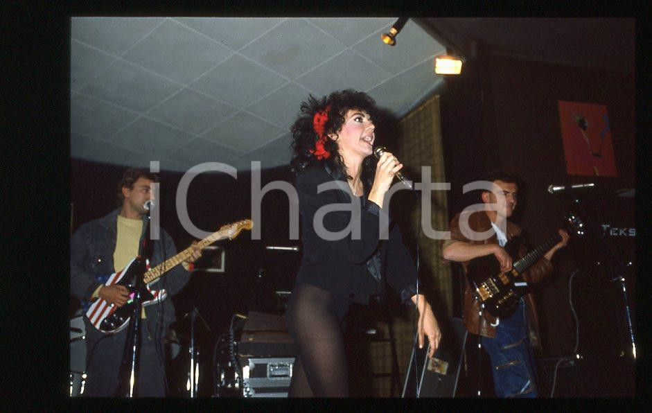 1985 ca ITALIA - MUSICA Marina FIORDALISO Concerto - 35 mm vintage slide (11) Diapositiva d'epoca, in formato 35 mm.CONDIZIONI: GOODE' severamente vietata la riproduzione. Tutti i diritti sono riservati.Nella diapositiva ICharta mette in vendita, sul negozio eBay e in esclusiva sul sito "icharta" il proprio archivio composto da numerose diapositive e negativi fotografici d'epoca, tutti originali e autentici, che attraversano la storia del costume italiano tra gli la fine degli anni Sessanta e Novanta.Si tratta di uno sguardo inedito sull'attualità , la politica, la vita quotidiana, il gossip e la cultura, che fotografa il cambiamento della nazione in quest'ultimo scorcio del XX secolo. Un'occasione unica per il mercato del collezionismo, che vede finalmente disponibile un archivio eccezionale per vastità , tematiche e condizioni, in un settore (il negativo fotografico e la diapositiva) di assoluta novità e dalle interessanti prospettive di investimento.  GOOD/buono   originale e autentica 1