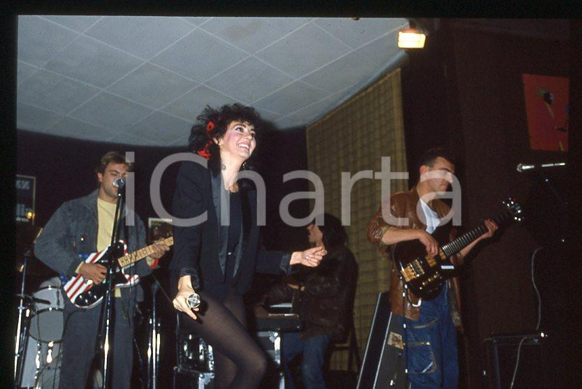 1985 ca ITALIA - MUSICA Marina FIORDALISO Concerto - 35 mm vintage slide (19) Diapositiva d'epoca, in formato 35 mm.CONDIZIONI: GOODE' severamente vietata la riproduzione. Tutti i diritti sono riservati.Nella diapositiva ICharta mette in vendita, sul negozio eBay e in esclusiva sul sito "icharta" il proprio archivio composto da numerose diapositive e negativi fotografici d'epoca, tutti originali e autentici, che attraversano la storia del costume italiano tra gli la fine degli anni Sessanta e Novanta.Si tratta di uno sguardo inedito sull'attualità , la politica, la vita quotidiana, il gossip e la cultura, che fotografa il cambiamento della nazione in quest'ultimo scorcio del XX secolo. Un'occasione unica per il mercato del collezionismo, che vede finalmente disponibile un archivio eccezionale per vastità , tematiche e condizioni, in un settore (il negativo fotografico e la diapositiva) di assoluta novità e dalle interessanti prospettive di investimento.  GOOD/buono   originale e autentica 1