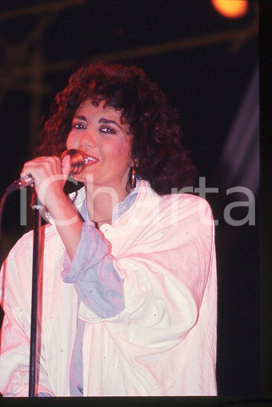 1985 ca ITALIA - MUSICA Marina FIORDALISO Concerto - 35 mm vintage slide (27) Diapositiva d'epoca, in formato 35 mm.CONDIZIONI: GOODE' severamente vietata la riproduzione. Tutti i diritti sono riservati.Nella diapositiva ICharta mette in vendita, sul negozio eBay e in esclusiva sul sito "icharta" il proprio archivio composto da numerose diapositive e negativi fotografici d'epoca, tutti originali e autentici, che attraversano la storia del costume italiano tra gli la fine degli anni Sessanta e Novanta.Si tratta di uno sguardo inedito sull'attualità , la politica, la vita quotidiana, il gossip e la cultura, che fotografa il cambiamento della nazione in quest'ultimo scorcio del XX secolo. Un'occasione unica per il mercato del collezionismo, che vede finalmente disponibile un archivio eccezionale per vastità , tematiche e condizioni, in un settore (il negativo fotografico e la diapositiva) di assoluta novità e dalle interessanti prospettive di investimento.  GOOD/buono   originale e autentica 1