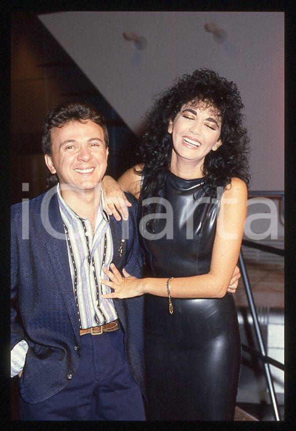 1985 ca MUSICA Marina FIORDALISO e PUPO Enzo GHINAZZI 35 mm vintage slide (3) Diapositiva d'epoca, in formato 35 mm.CONDIZIONI: GOODE' severamente vietata la riproduzione. Tutti i diritti sono riservati.Nella diapositiva ICharta mette in vendita, sul negozio eBay e in esclusiva sul sito "icharta" il proprio archivio composto da numerose diapositive e negativi fotografici d'epoca, tutti originali e autentici, che attraversano la storia del costume italiano tra gli la fine degli anni Sessanta e Novanta.Si tratta di uno sguardo inedito sull'attualità , la politica, la vita quotidiana, il gossip e la cultura, che fotografa il cambiamento della nazione in quest'ultimo scorcio del XX secolo. Un'occasione unica per il mercato del collezionismo, che vede finalmente disponibile un archivio eccezionale per vastità , tematiche e condizioni, in un settore (il negativo fotografico e la diapositiva) di assoluta novità e dalle interessanti prospettive di investimento.  GOOD/buono   originale e autentica 1