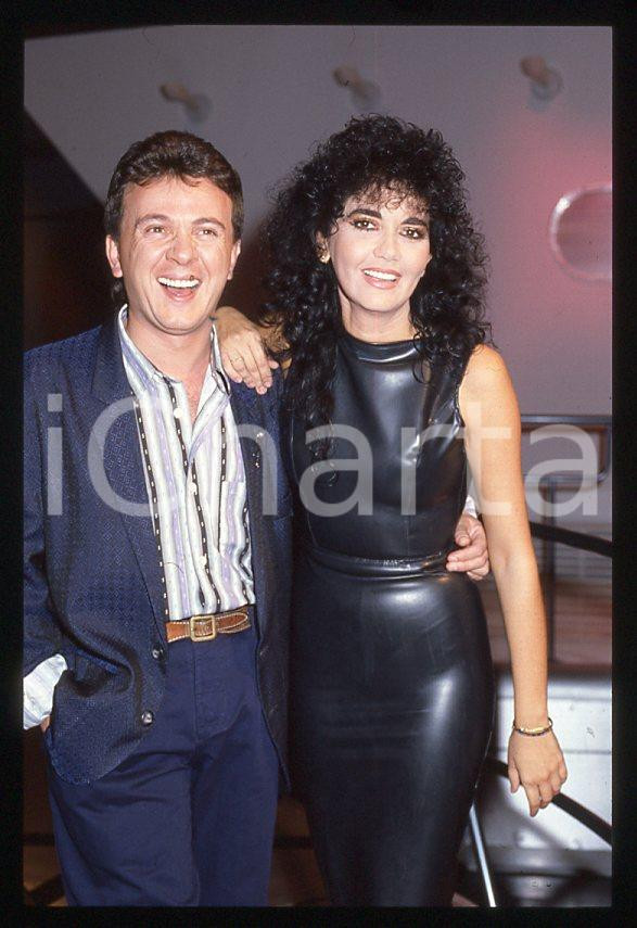 1985 ca MUSICA Marina FIORDALISO e PUPO Enzo GHINAZZI 35 mm vintage slide (2) Diapositiva d'epoca, in formato 35 mm.CONDIZIONI: GOODE' severamente vietata la riproduzione. Tutti i diritti sono riservati.Nella diapositiva ICharta mette in vendita, sul negozio eBay e in esclusiva sul sito "icharta" il proprio archivio composto da numerose diapositive e negativi fotografici d'epoca, tutti originali e autentici, che attraversano la storia del costume italiano tra gli la fine degli anni Sessanta e Novanta.Si tratta di uno sguardo inedito sull'attualità , la politica, la vita quotidiana, il gossip e la cultura, che fotografa il cambiamento della nazione in quest'ultimo scorcio del XX secolo. Un'occasione unica per il mercato del collezionismo, che vede finalmente disponibile un archivio eccezionale per vastità , tematiche e condizioni, in un settore (il negativo fotografico e la diapositiva) di assoluta novità e dalle interessanti prospettive di investimento.  GOOD/buono   originale e autentica 1