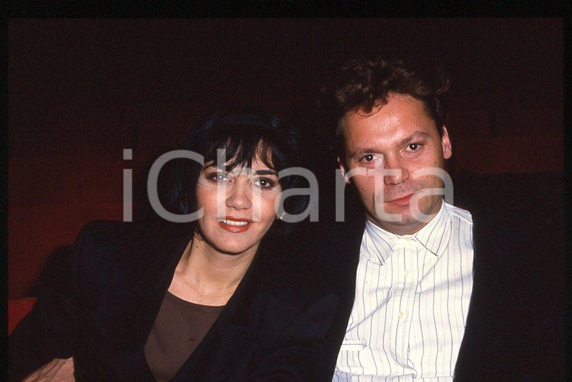 1985 ca ITALIA - MUSICA Marina FIORDALISO con il marito - 35 mm vintage slide 1 Diapositiva d'epoca, in formato 35 mm.CONDIZIONI: GOODE' severamente vietata la riproduzione. Tutti i diritti sono riservati.Nella diapositiva ICharta mette in vendita, sul negozio eBay e in esclusiva sul sito "icharta" il proprio archivio composto da numerose diapositive e negativi fotografici d'epoca, tutti originali e autentici, che attraversano la storia del costume italiano tra gli la fine degli anni Sessanta e Novanta.Si tratta di uno sguardo inedito sull'attualità , la politica, la vita quotidiana, il gossip e la cultura, che fotografa il cambiamento della nazione in quest'ultimo scorcio del XX secolo. Un'occasione unica per il mercato del collezionismo, che vede finalmente disponibile un archivio eccezionale per vastità , tematiche e condizioni, in un settore (il negativo fotografico e la diapositiva) di assoluta novità e dalle interessanti prospettive di investimento.  GOOD/buono   originale e autentica 1