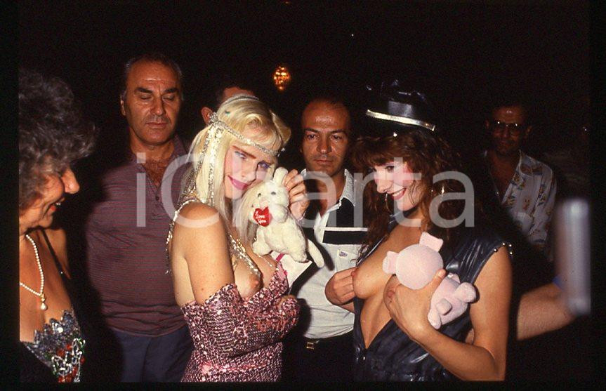 1980 ca CICCIOLINA Ilona STALLER - RAMBA Ileana CARISIO - 35 mm vintage slide 4 Diapositiva d'epoca, in formato 35 mm.CONDIZIONI: GOODE' severamente vietata la riproduzione. Tutti i diritti sono riservati.Nella diapositiva ICharta mette in vendita, sul negozio eBay e in esclusiva sul sito "icharta" il proprio archivio composto da numerose diapositive e negativi fotografici d'epoca, tutti originali e autentici, che attraversano la storia del costume italiano tra gli la fine degli anni Sessanta e Novanta.Si tratta di uno sguardo inedito sull'attualità , la politica, la vita quotidiana, il gossip e la cultura, che fotografa il cambiamento della nazione in quest'ultimo scorcio del XX secolo. Un'occasione unica per il mercato del collezionismo, che vede finalmente disponibile un archivio eccezionale per vastità , tematiche e condizioni, in un settore (il negativo fotografico e la diapositiva) di assoluta novità e dalle interessanti prospettive di investimento.  GOOD/buono   originale e autentica 1