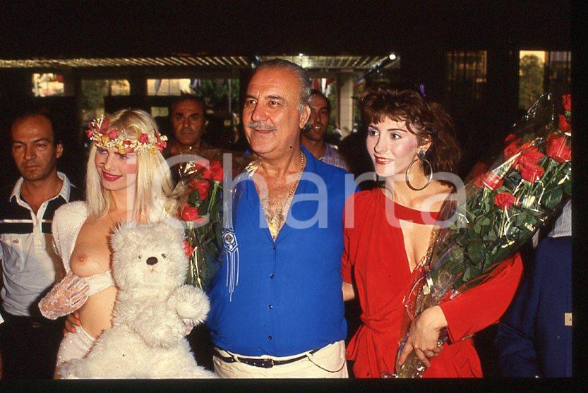 1980 ca CICCIOLINA Ilona STALLER - RAMBA - M. LEFAKIS - 35 mm vintage slide 14 Diapositiva d'epoca, in formato 35 mm.CONDIZIONI: GOODE' severamente vietata la riproduzione. Tutti i diritti sono riservati.Nella diapositiva ICharta mette in vendita, sul negozio eBay e in esclusiva sul sito "icharta" il proprio archivio composto da numerose diapositive e negativi fotografici d'epoca, tutti originali e autentici, che attraversano la storia del costume italiano tra gli la fine degli anni Sessanta e Novanta.Si tratta di uno sguardo inedito sull'attualità , la politica, la vita quotidiana, il gossip e la cultura, che fotografa il cambiamento della nazione in quest'ultimo scorcio del XX secolo. Un'occasione unica per il mercato del collezionismo, che vede finalmente disponibile un archivio eccezionale per vastità , tematiche e condizioni, in un settore (il negativo fotografico e la diapositiva) di assoluta novità e dalle interessanti prospettive di investimento.  GOOD/buono   originale e autentica 1