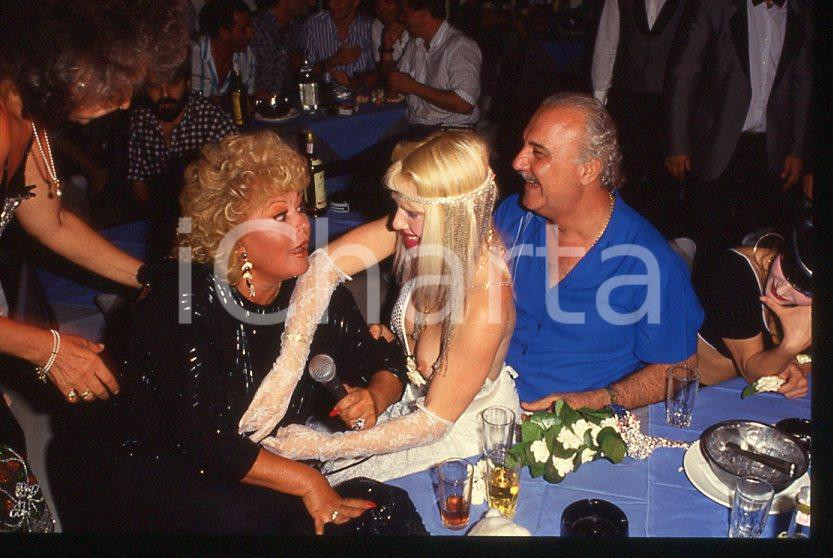 1980 ca CICCIOLINA Ilona STALLER - M. LEFAKIS *35 mm vintage slide 21 Diapositiva d'epoca, in formato 35 mm.CONDIZIONI: GOODE' severamente vietata la riproduzione. Tutti i diritti sono riservati.Nella diapositiva ICharta mette in vendita, sul negozio eBay e in esclusiva sul sito "icharta" il proprio archivio composto da numerose diapositive e negativi fotografici d'epoca, tutti originali e autentici, che attraversano la storia del costume italiano tra gli la fine degli anni Sessanta e Novanta.Si tratta di uno sguardo inedito sull'attualità , la politica, la vita quotidiana, il gossip e la cultura, che fotografa il cambiamento della nazione in quest'ultimo scorcio del XX secolo. Un'occasione unica per il mercato del collezionismo, che vede finalmente disponibile un archivio eccezionale per vastità , tematiche e condizioni, in un settore (il negativo fotografico e la diapositiva) di assoluta novità e dalle interessanti prospettive di investimento.   GOOD/buono   originale e autentica 1