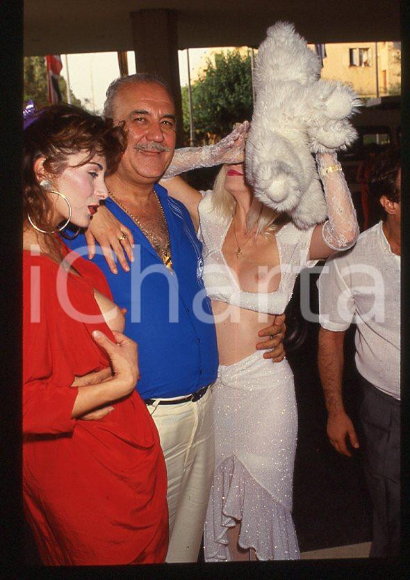 1980 ca CICCIOLINA Ilona STALLER - RAMBA - M. LEFAKIS - 35 mm vintage slide 20 Diapositiva d'epoca, in formato 35 mm.CONDIZIONI: GOODE' severamente vietata la riproduzione. Tutti i diritti sono riservati.Nella diapositiva ICharta mette in vendita, sul negozio eBay e in esclusiva sul sito "icharta" il proprio archivio composto da numerose diapositive e negativi fotografici d'epoca, tutti originali e autentici, che attraversano la storia del costume italiano tra gli la fine degli anni Sessanta e Novanta.Si tratta di uno sguardo inedito sull'attualità , la politica, la vita quotidiana, il gossip e la cultura, che fotografa il cambiamento della nazione in quest'ultimo scorcio del XX secolo. Un'occasione unica per il mercato del collezionismo, che vede finalmente disponibile un archivio eccezionale per vastità , tematiche e condizioni, in un settore (il negativo fotografico e la diapositiva) di assoluta novità e dalle interessanti prospettive di investimento.  GOOD/buono   originale e autentica 1