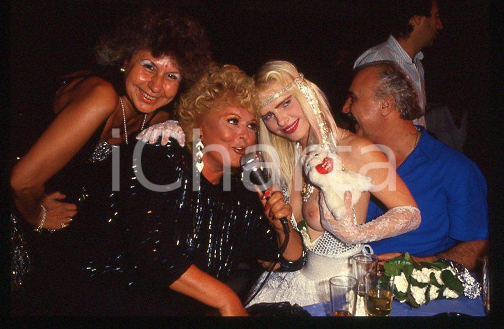 1980 ca CICCIOLINA Ilona STALLER Michalis LEFAKIS *35 mm vintage slide 2 Diapositiva d'epoca, in formato 35 mm.CONDIZIONI: GOODE' severamente vietata la riproduzione. Tutti i diritti sono riservati.Nella diapositiva ICharta mette in vendita, sul negozio eBay e in esclusiva sul sito "icharta" il proprio archivio composto da numerose diapositive e negativi fotografici d'epoca, tutti originali e autentici, che attraversano la storia del costume italiano tra gli la fine degli anni Sessanta e Novanta.Si tratta di uno sguardo inedito sull'attualità , la politica, la vita quotidiana, il gossip e la cultura, che fotografa il cambiamento della nazione in quest'ultimo scorcio del XX secolo. Un'occasione unica per il mercato del collezionismo, che vede finalmente disponibile un archivio eccezionale per vastità , tematiche e condizioni, in un settore (il negativo fotografico e la diapositiva) di assoluta novità e dalle interessanti prospettive di investimento.  GOOD/buono   originale e autentica 1