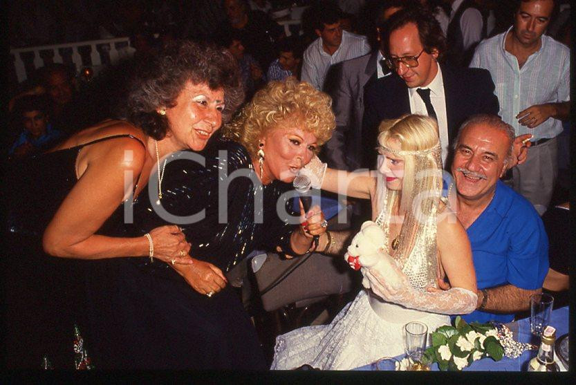 1980 ca CICCIOLINA Ilona STALLER Michalis LEFAKIS *35 mm vintage slide 8 Diapositiva d'epoca, in formato 35 mm.CONDIZIONI: GOODE' severamente vietata la riproduzione. Tutti i diritti sono riservati.Nella diapositiva ICharta mette in vendita, sul negozio eBay e in esclusiva sul sito "icharta" il proprio archivio composto da numerose diapositive e negativi fotografici d'epoca, tutti originali e autentici, che attraversano la storia del costume italiano tra gli la fine degli anni Sessanta e Novanta.Si tratta di uno sguardo inedito sull'attualità , la politica, la vita quotidiana, il gossip e la cultura, che fotografa il cambiamento della nazione in quest'ultimo scorcio del XX secolo. Un'occasione unica per il mercato del collezionismo, che vede finalmente disponibile un archivio eccezionale per vastità , tematiche e condizioni, in un settore (il negativo fotografico e la diapositiva) di assoluta novità e dalle interessanti prospettive di investimento.  GOOD/buono   originale e autentica 1