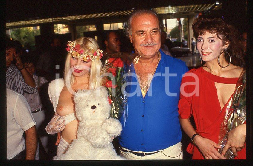 1980 ca CICCIOLINA Ilona STALLER - RAMBA Michalis LEFAKIS *35 mm vintage slide 1 Diapositiva d'epoca, in formato 35 mm.CONDIZIONI: GOODE' severamente vietata la riproduzione. Tutti i diritti sono riservati.Nella diapositiva ICharta mette in vendita, sul negozio eBay e in esclusiva sul sito "icharta" il proprio archivio composto da numerose diapositive e negativi fotografici d'epoca, tutti originali e autentici, che attraversano la storia del costume italiano tra gli la fine degli anni Sessanta e Novanta.Si tratta di uno sguardo inedito sull'attualità , la politica, la vita quotidiana, il gossip e la cultura, che fotografa il cambiamento della nazione in quest'ultimo scorcio del XX secolo. Un'occasione unica per il mercato del collezionismo, che vede finalmente disponibile un archivio eccezionale per vastità , tematiche e condizioni, in un settore (il negativo fotografico e la diapositiva) di assoluta novità e dalle interessanti prospettive di investimento.  GOOD/buono   originale e autentica 1