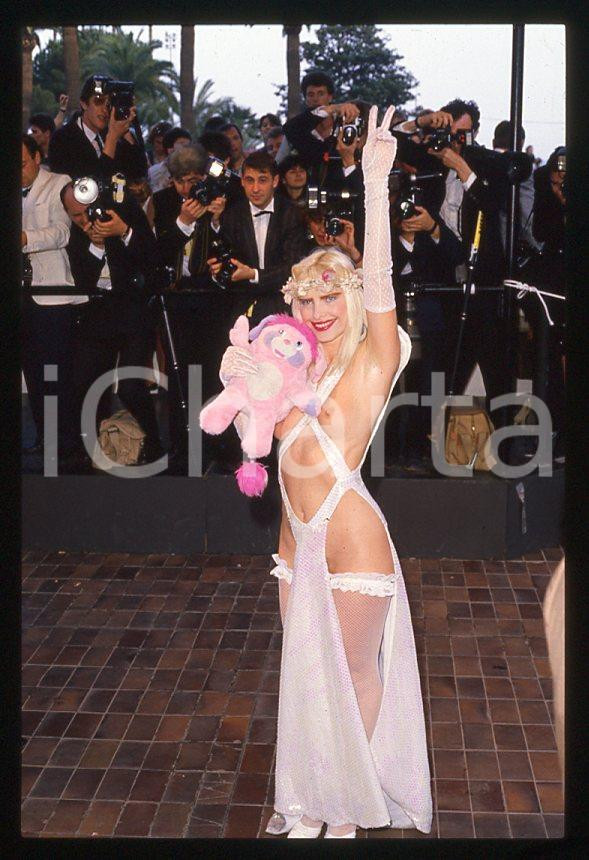 1988 CICCIOLINA Ilona STALLER al Festival di CANNES *35 mm vintage slide (6) Diapositiva d'epoca, in formato 35 mm.CONDIZIONI: GOODE' severamente vietata la riproduzione. Tutti i diritti sono riservati.Nella diapositiva ICharta mette in vendita, sul negozio eBay e in esclusiva sul sito "icharta" il proprio archivio composto da numerose diapositive e negativi fotografici d'epoca, tutti originali e autentici, che attraversano la storia del costume italiano tra gli la fine degli anni Sessanta e Novanta.Si tratta di uno sguardo inedito sull'attualità , la politica, la vita quotidiana, il gossip e la cultura, che fotografa il cambiamento della nazione in quest'ultimo scorcio del XX secolo. Un'occasione unica per il mercato del collezionismo, che vede finalmente disponibile un archivio eccezionale per vastità , tematiche e condizioni, in un settore (il negativo fotografico e la diapositiva) di assoluta novità e dalle interessanti prospettive di investimento.  GOOD/buono   originale e autentica 1