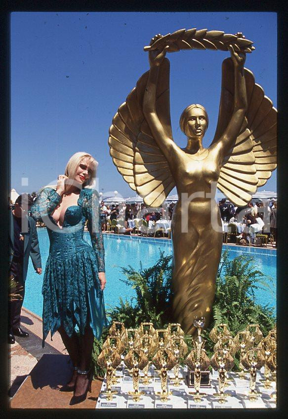 1996 CICCIOLINA Ilona STALLER Hot d'or CANNES *35 mm vintage slide (2) Diapositiva d'epoca, in formato 35 mm.CONDIZIONI: GOODE' severamente vietata la riproduzione. Tutti i diritti sono riservati.Nella diapositiva ICharta mette in vendita, sul negozio eBay e in esclusiva sul sito "icharta" il proprio archivio composto da numerose diapositive e negativi fotografici d'epoca, tutti originali e autentici, che attraversano la storia del costume italiano tra gli la fine degli anni Sessanta e Novanta.Si tratta di uno sguardo inedito sull'attualità , la politica, la vita quotidiana, il gossip e la cultura, che fotografa il cambiamento della nazione in quest'ultimo scorcio del XX secolo. Un'occasione unica per il mercato del collezionismo, che vede finalmente disponibile un archivio eccezionale per vastità , tematiche e condizioni, in un settore (il negativo fotografico e la diapositiva) di assoluta novità e dalle interessanti prospettive di investimento.  GOOD/buono   originale e autentica 1