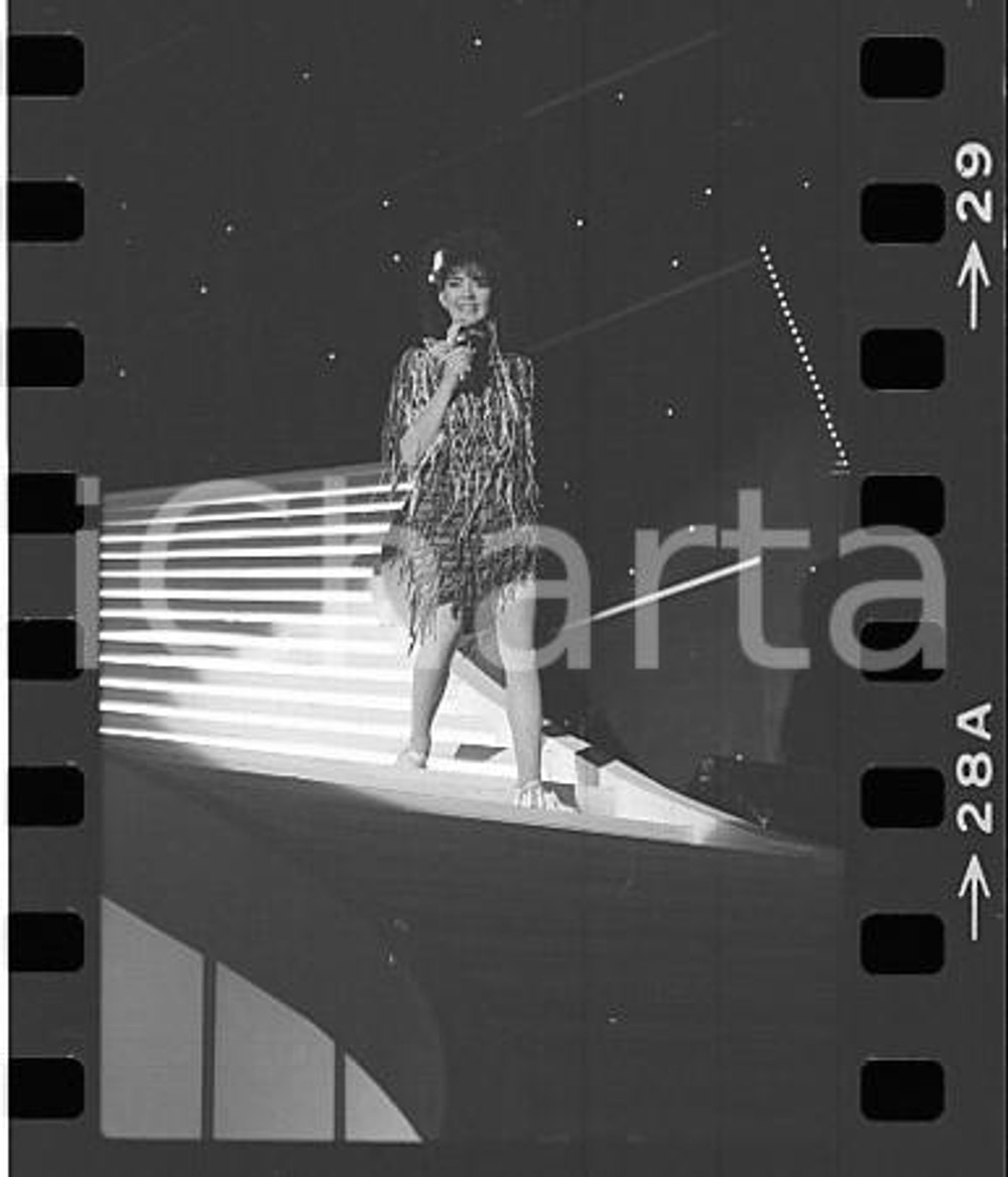 1984 FESTIVAL SANREMO FIORDALISO ospite della serata NEGATIVO ORIGINALE Mentre interpreta Non voglio mica la lunaNegativo originale in bianco e nero (su pellicola), in formato 35mm CONDIZIONI: FAIRE' severamente vietata la riproduzione. Tutti i diritti sono riservati. ICharta mette in vendita, sul negozio eBay e in esclusiva sul sito "icharta" il proprio archivio composto da numerose diapositive e negativi fotografici d'epoca, tutti originali e autentici, che attraversano la storia del costume italiano tra gli la fine degli anni Sessanta e Novanta.Si tratta di uno sguardo inedito sull'attualità, la politica, la vita quotidiana, il gossip e la cultura, che fotografa il cambiamento della nazione in quest'ultimo scorcio del XX secolo. Un'occasione unica per il mercato del collezionismo, che vede finalmente disponibile un archivio eccezionale per vastità, tematiche e condizioni, in un settore (il negativo fotografico e la diapositiva) di assoluta novità e dalle interessanti prospettive di investimento. FAIR/discreto   originale e autentica 1