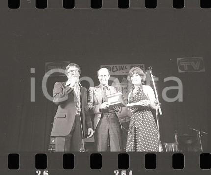 1976 VOTA LA VOCE Gigi VESIGNA e Dino SARTI sul palco 3 NEGATIVO ORIGINALE Negativo originale in bianco e nero (su pellicola), in formato 35mm CONDIZIONI:  FAIRE' severamente vietata la riproduzione. Tutti i diritti sono riservati. ICharta mette in vendita, sul negozio eBay e in esclusiva sul sito "icharta" il proprio archivio composto da numerose diapositive e negativi fotografici d'epoca, tutti originali e autentici, che attraversano la storia del costume italiano tra gli la fine degli anni Sessanta e Novanta.Si tratta di uno sguardo inedito sull'attualità, la politica, la vita quotidiana, il gossip e la cultura, che fotografa il cambiamento della nazione in quest'ultimo scorcio del XX secolo. Un'occasione unica per il mercato del collezionismo, che vede finalmente disponibile un archivio eccezionale per vastità, tematiche e condizioni, in un settore (il negativo fotografico e la diapositiva) di assoluta novità e dalle interessanti prospettive di investimento. FAIR/discreto   originale e autentica 1