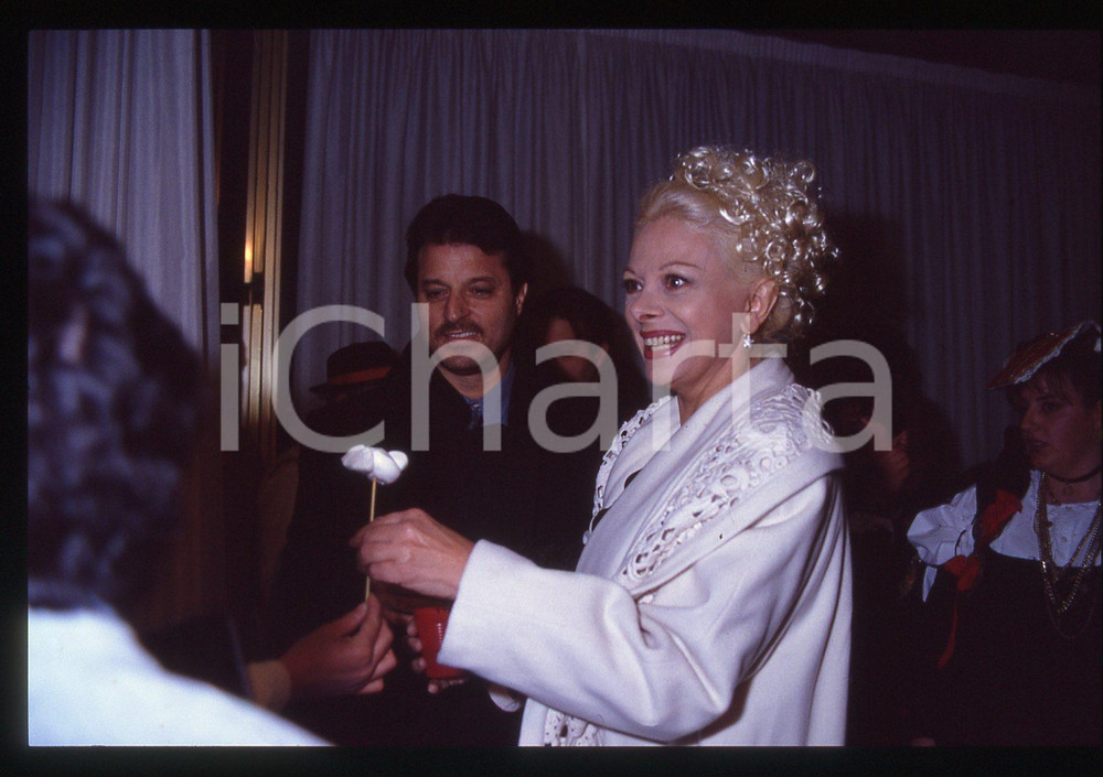 35mm vintage slide* 1990ca COSTUME - Sandra MILO e Pino LO PRESTI   Diapositiva d'epoca, in formato 35 mm. CONDIZIONI: GOODE' severamente vietata la riproduzione. Tutti i diritti sono riservati. ICharta mette in vendita, sul negozio eBay e in esclusiva sul sito "icharta" il proprio archivio composto da numerose diapositive e negativi fotografici d'epoca, tutti originali e autentici, che attraversano la storia del costume italiano tra gli la fine degli anni Sessanta e Novanta.Si tratta di uno sguardo inedito sull'attualit&agrave;, la politica, la vita quotidiana, il gossip e la cultura, che fotografa il cambiamento della nazione in quest'ultimo scorcio del XX secolo. Un'occasione unica per il mercato del collezionismo, che vede finalmente disponibile un archivio eccezionale per vastit&agrave;, tematiche e condizioni, in un settore (il negativo fotografico e la diapositiva) di assoluta novit&agrave; e dalle interessanti prospettive di investimento.    originale e autentica 1