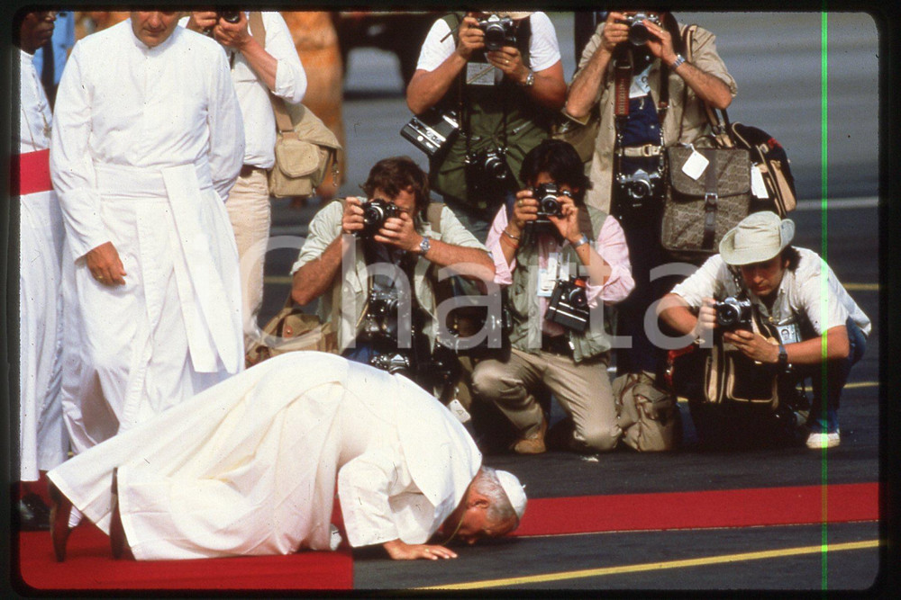 35mm vintage slide* 1982 Ivory Coast, Giovanni Paolo II, facing the Press 1  Diapositiva d'epoca, in formato 35 mm.CONDIZIONI: GOODE' severamente vietata la riproduzione. Tutti i diritti sono riservati.Nella diapositiva ICharta mette in vendita, sul negozio eBay e in esclusiva sul sito "icharta" il proprio archivio composto da numerose diapositive e negativi fotografici d'epoca, tutti originali e autentici, che attraversano la storia del costume italiano tra gli la fine degli anni Sessanta e Novanta.Si tratta di uno sguardo inedito sull'attualit&agrave;, la politica, la vita quotidiana, il gossip e la cultura, che fotografa il cambiamento della nazione in quest'ultimo scorcio del XX secolo. Un'occasione unica per il mercato del collezionismo, che vede finalmente disponibile un archivio eccezionale per vastit&agrave;, tematiche e condizioni, in un settore (il negativo fotografico e la diapositiva) di assoluta novit&agrave; e dalle interessanti prospettive di investimento.  FAIR/discreto   originale e autentica 1