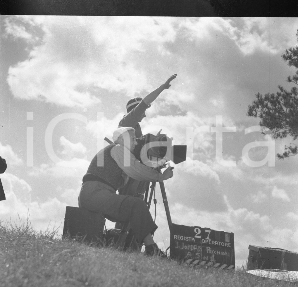 1949 IL FILM DIMENTICATO - LONATO - LEGGASI DESCRIZIONE *NEGATIVO ORIGINALE 9 Negativo originale in bianco e nero su pellicola.Nel febbraio del 1949, nella zona di Lonato, con alcune incursioni verso Brescia, ebbero inizio le riprese di un film dal titolo: Il Pellegrino . Le informazioni su questa produzione sono estremamente rare, quasi evanescenti. Il regista è indicato come “J. Jordan”, un nome che sembra uno pseudonimo e che non compare in alcun archivio cinematografico noto, alimentando il mistero sulla sua vera identità.Unico elemento certo è il protagonista, Nino Filippini, attore proveniente dalla Compagnia Maltagliati–Gassman di Roma. L'operatore di macchina viene indicato come un certo “G. Pecchioni”, mentre il fotografo di scena è il bresciano Alberto Sorlini, la cui presenza è una delle poche conferme tangibili di questa produzione.Nonostante queste rare testimonianze, rimangono avvolti nell'oscurità sia la trama del film che il suo destino. Nessun fotogramma, nessuna copia, nessun documento sembra essere sopravvissuto fatta eccezione per i pochi negativi fotografici qui proposti in vendita. Il Pellegrino appare oggi come un'opera fantasma, un frammento di storia dimenticato. Nel negativo qui in vendita è raffigurato: "J.Jordan", il regista (in piedi) con l'operatore Pecchioni. E' SEVERAMENTE VIETATA LA RIPRODUZIONE.TUTTI I DIRITTI SONO RISERVATI. CONDIZIONI:FAIR/discretoFORMATO: cm 6 x 6 originale e autentica 1