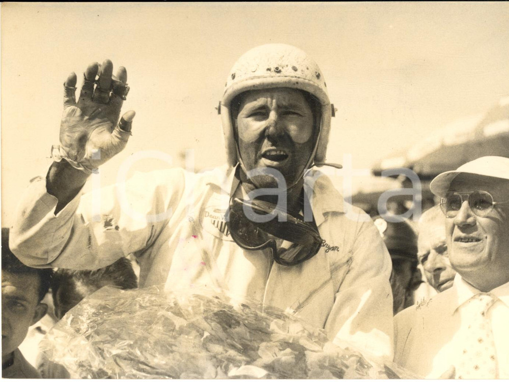 1957 AUTOMOBILISMO MONZA 500 MIGLIA Jimmy BRYAN dopo la vittoria - Foto 18x13  Fotografia d'epoca con didascalia coeva al verso.   CONDIZIONI: FAIR (lieve macchia di inchiostro e sovraimpressione della didascalia)FORMATO: 18x13 cm      originale e autentica 1