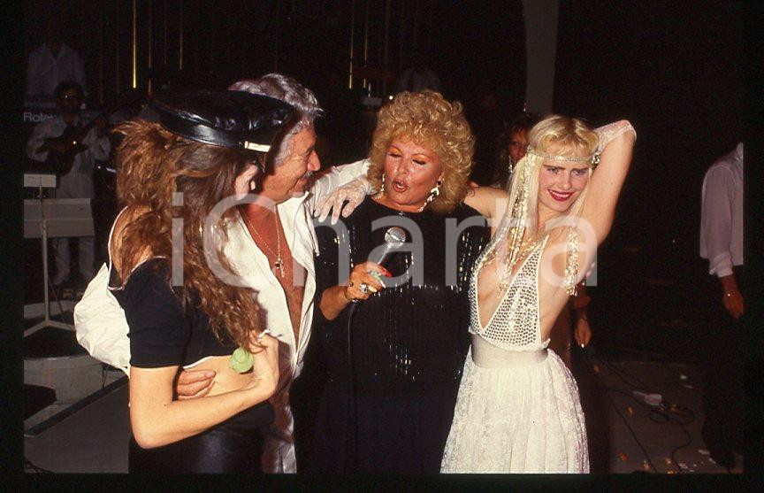 1980 ca CICCIOLINA Ilona STALLER - RAMBA Ileana CARISIO - 35mm vintage slide 8 Diapositiva d'epoca, in formato 35 mm.Nella diapositiva compare inoltre M. Lefakis. CONDIZIONI: GOODE' severamente vietata la riproduzione. Tutti i diritti sono riservati.Nella diapositiva ICharta mette in vendita, sul negozio eBay e in esclusiva sul sito "icharta" il proprio archivio composto da numerose diapositive e negativi fotografici d'epoca, tutti originali e autentici, che attraversano la storia del costume italiano tra gli la fine degli anni Sessanta e Novanta.Si tratta di uno sguardo inedito sull'attualità , la politica, la vita quotidiana, il gossip e la cultura, che fotografa il cambiamento della nazione in quest'ultimo scorcio del XX secolo. Un'occasione unica per il mercato del collezionismo, che vede finalmente disponibile un archivio eccezionale per vastità , tematiche e condizioni, in un settore (il negativo fotografico e la diapositiva) di assoluta novità e dalle interessanti prospettive di investimento.   GOOD/buono   originale e autentica 1