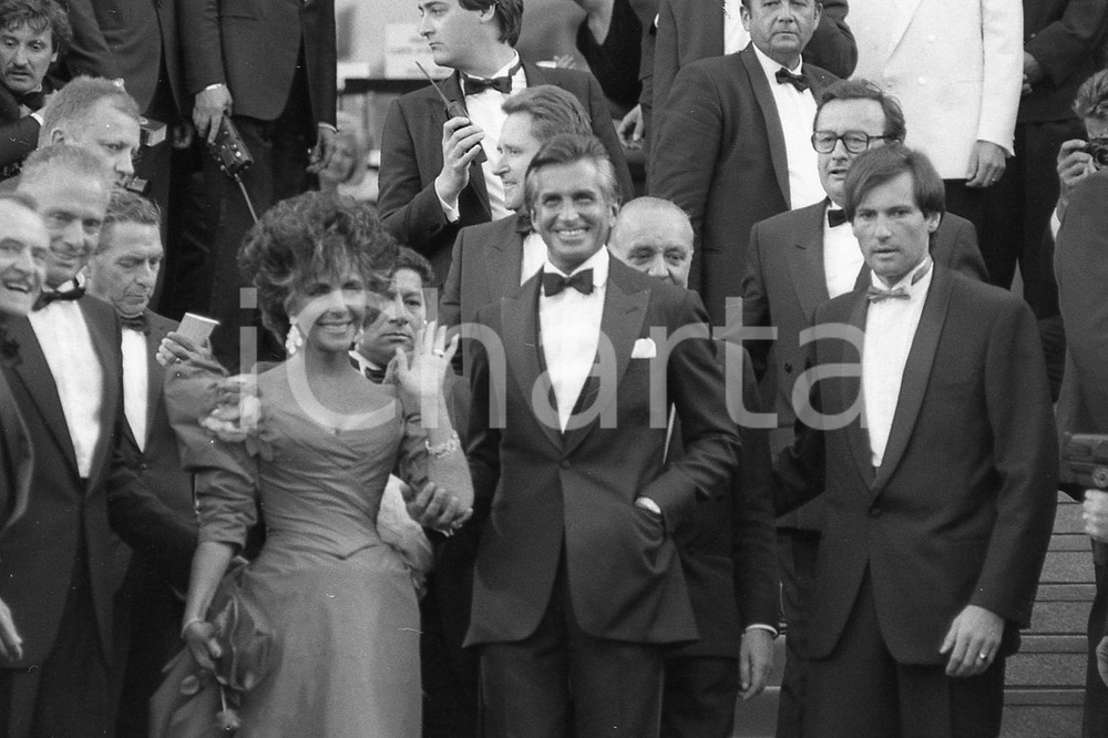 1987 CANNES Liz TAYLOR e George HAMILTON suL red carpet * NEGATIVO ORIGINALE 14 Negativo originale in bianco e nero, su pellicola, in formato 35mm  E' SEVERAMENTE VIETATA LA RIPRODUZIONE.TUTTI I DIRITTI SONO RISERVATI.ICharta mette in vendita, sul negozio eBay e in esclusiva sul sito "icharta" il proprio archivio composto da numerose diapositive e negativi fotografici d'epoca, tutti originali e autentici, che attraversano la storia del costume italiano tra gli la fine degli anni Sessanta e Novanta.Si tratta di uno sguardo inedito sull'attualità, la politica, la vita quotidiana, il gossip e la cultura, che fotografa il cambiamento della nazione in quest'ultimo scorcio del XX secolo. Un'occasione unica per il mercato del collezionismo, che vede finalmente disponibile un archivio eccezionale per vastità, tematiche e condizioni, in un settore (il negativo fotografico e la diapositiva) di assoluta novità e dalle interessanti prospettive di investimento.  FAIR/discreto  FORMATO: 35mm originale e autentica 1