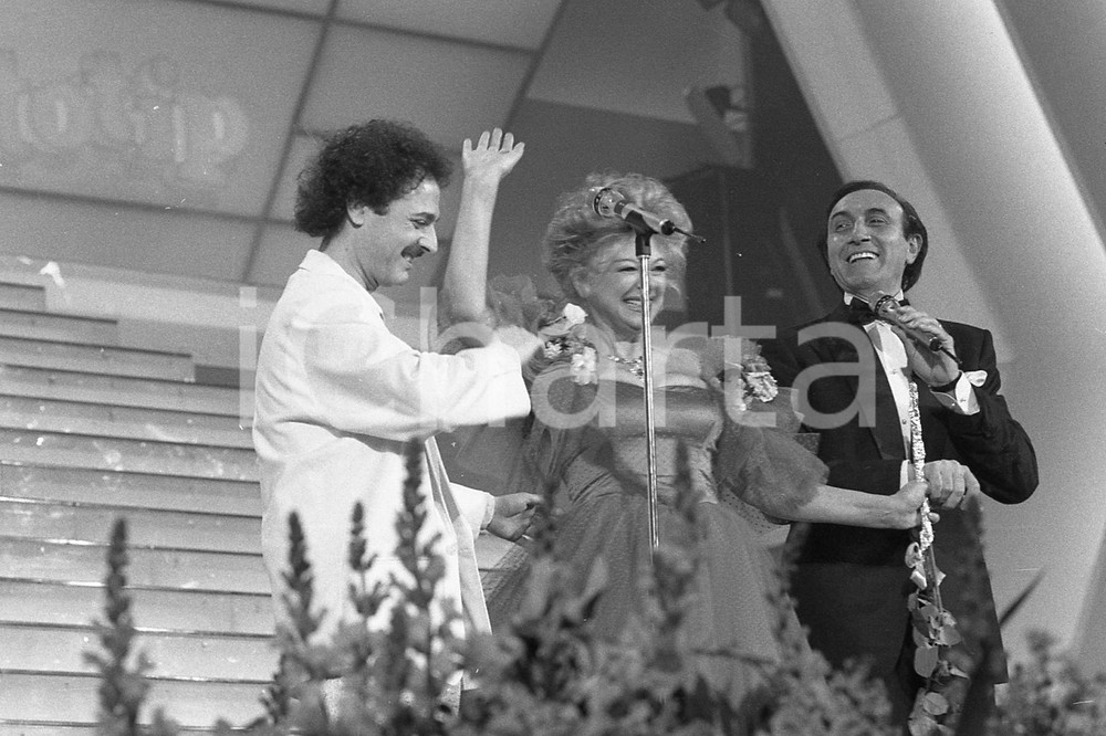 1987 SANREMO Eduardo DE CRESCENZO Pippo BAUDO sul palco * NEGATIVO ORIGINALE Negativo originale in bianco e nero, su pellicola, in formato 35mm  E' SEVERAMENTE VIETATA LA RIPRODUZIONE.TUTTI I DIRITTI SONO RISERVATI.ICharta mette in vendita, sul negozio eBay e in esclusiva sul sito "icharta" il proprio archivio composto da numerose diapositive e negativi fotografici d'epoca, tutti originali e autentici, che attraversano la storia del costume italiano tra gli la fine degli anni Sessanta e Novanta.Si tratta di uno sguardo inedito sull'attualità, la politica, la vita quotidiana, il gossip e la cultura, che fotografa il cambiamento della nazione in quest'ultimo scorcio del XX secolo. Un'occasione unica per il mercato del collezionismo, che vede finalmente disponibile un archivio eccezionale per vastità, tematiche e condizioni, in un settore (il negativo fotografico e la diapositiva) di assoluta novità e dalle interessanti prospettive di investimento.  FAIR/discreto  FORMATO: 35mm originale e autentica 1