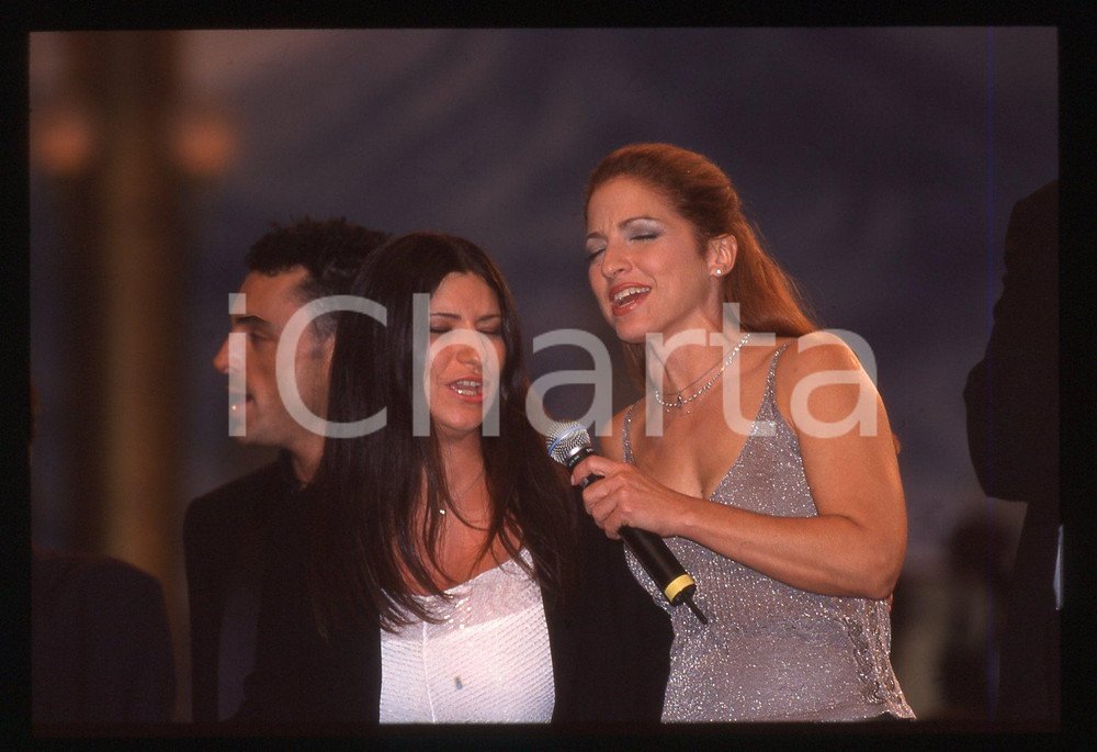 35mm vintage slide*1999 Modena PAVAROTTI & Friends Laura PAUSINI Gloria ESTEFAN   Diapositiva d'epoca, in formato 35 mm.Con loro nella foto anche Alex Britti. CONDIZIONI: GOODE' severamente vietata la riproduzione. Tutti i diritti sono riservati. ICharta mette in vendita, sul negozio eBay e in esclusiva sul sito "icharta" il proprio archivio composto da numerose diapositive e negativi fotografici d'epoca, tutti originali e autentici, che attraversano la storia del costume italiano tra gli la fine degli anni Sessanta e Novanta.Si tratta di uno sguardo inedito sull'attualit&agrave;, la politica, la vita quotidiana, il gossip e la cultura, che fotografa il cambiamento della nazione in quest'ultimo scorcio del XX secolo. Un'occasione unica per il mercato del collezionismo, che vede finalmente disponibile un archivio eccezionale per vastit&agrave;, tematiche e condizioni, in un settore (il negativo fotografico e la diapositiva) di assoluta novit&agrave; e dalle interessanti prospettive di investimento.     originale e autentica 1