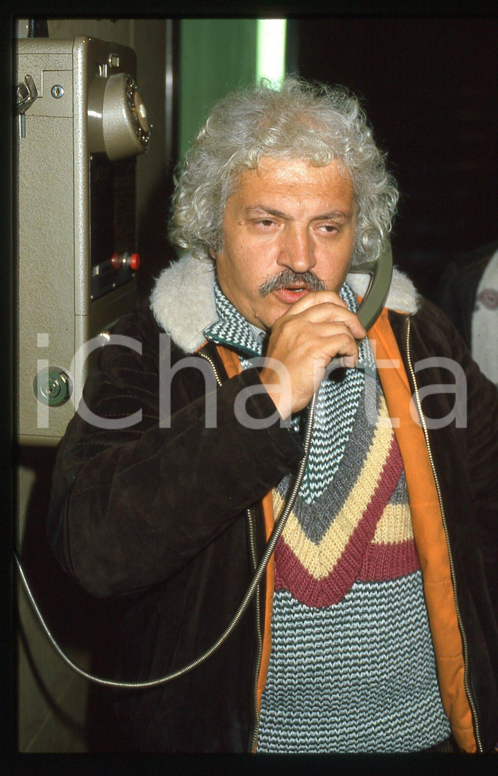 35mm vintage slide* 1985ca ITALIA MUSICA Bruno LAUZI al telefono pubblico (1)  Diapositiva d'epoca, in formato 35 mm. CONDIZIONI: GOODE' severamente vietata la riproduzione. Tutti i diritti sono riservati.Nella diapositiva ICharta mette in vendita, sul negozio eBay e in esclusiva sul sito "icharta" il proprio archivio composto da numerose diapositive e negativi fotografici d'epoca, tutti originali e autentici, che attraversano la storia del costume italiano tra gli la fine degli anni Sessanta e Novanta.Si tratta di uno sguardo inedito sull'attualit&agrave;, la politica, la vita quotidiana, il gossip e la cultura, che fotografa il cambiamento della nazione in quest'ultimo scorcio del XX secolo. Un'occasione unica per il mercato del collezionismo, che vede finalmente disponibile un archivio eccezionale per vastit&agrave;, tematiche e condizioni, in un settore (il negativo fotografico e la diapositiva) di assoluta novit&agrave; e dalle interessanti prospettive di investimento.     originale e autentica 1