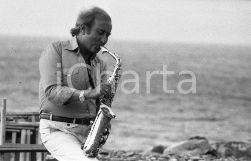 1975 Fausto PAPETTI in riva al mare con il sax  NEGATIVO ORIGINALE 3 Negativo originale in bianco e nero su pellicola.  E' SEVERAMENTE VIETATA LA RIPRODUZIONE.TUTTI I DIRITTI SONO RISERVATI.ICharta mette in vendita, sul negozio eBay e in esclusiva sul sito "icharta" il proprio archivio composto da numerose diapositive e negativi fotografici d'epoca, tutti originali e autentici.Si tratta di uno sguardo inedito sull'attualità, la politica, la vita quotidiana, il gossip e la cultura, che fotografa il cambiamento della nazione (e non solo) tra il 1890 ed il 1990 circa. Un'occasione unica per il mercato del collezionismo, che vede finalmente disponibile un archivio eccezionale per vastità, tematiche e condizioni, in un settore (il negativo fotografico e la diapositiva) di assoluta novità e dalle interessanti prospettive di investimento. CONDIZIONI:FAIR/discretoFORMATO: 35mm originale e autentica 1