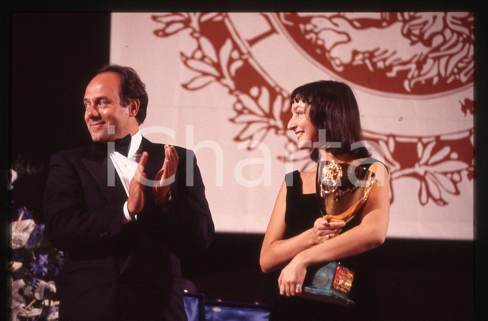 35mm vintage slide*1994 VENEZIA Carlo VERDONE premia Maria DE MEDEIROS (1)  Diapositiva d'epoca, in formato 35 mm.Nella diapositiva appare Carlo Verdone che consegnaCoppa Volpi all'attrice.                                                                       CONDIZIONI: GOODE' severamente vietata la riproduzione. Tutti i diritti sono riservati. ICharta mette in vendita, sul negozio eBay e in esclusiva sul sito "icharta" il proprio archivio composto da numerose diapositive e negativi fotografici d'epoca, tutti originali e autentici, che attraversano la storia del costume italiano tra gli la fine degli anni Sessanta e Novanta.Si tratta di uno sguardo inedito sull'attualit&agrave;, la politica, la vita quotidiana, il gossip e la cultura, che fotografa il cambiamento della nazione in quest'ultimo scorcio del XX secolo. Un'occasione unica per il mercato del collezionismo, che vede finalmente disponibile un archivio eccezionale per vastit&agrave;, tematiche e condizioni, in un settore (il negativo fotografico e la diapositiva) di assoluta novit&agrave; e dalle interessanti prospettive di investimento.  originale e autentica 1