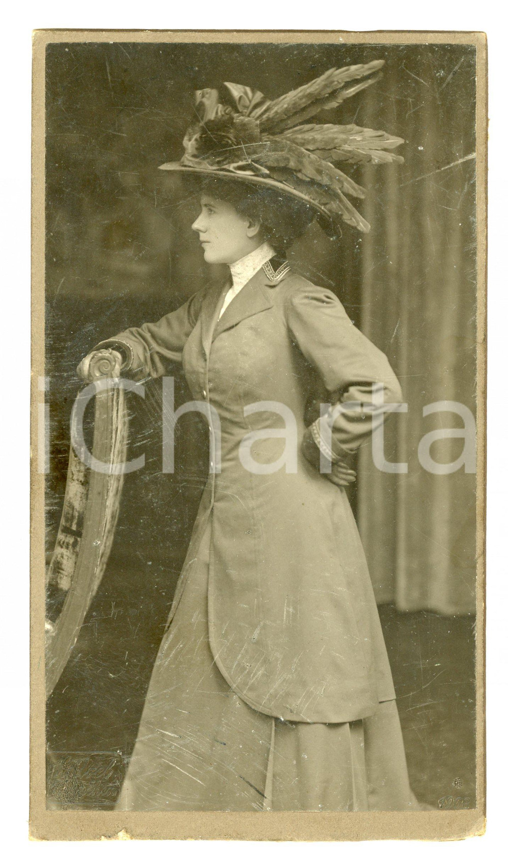 1908 MUNCHEN Donna con cappello di piume - Foto Gebrüder Lützel Fotografia d'epoca montata su cartoncino.FOTOGRAFO: Gebrüder Lützel - Monaco CONDIZIONI:FAIR/discreto Graffi al recto, lievi abrasioni al margine inferiore e al versoFORMATO: 11x19  cm originale e autentica 1