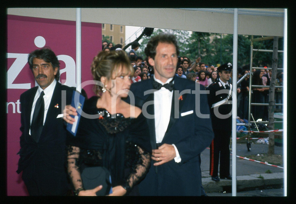 1995 ca MILANO Franco BARESI Maura LARI notte TELEGATTI *35mm VINTAGE SLIDE 2 Diapositiva d'epoca originale.  E' SEVERAMENTE VIETATA LA RIPRODUZIONE.TUTTI I DIRITTI SONO RISERVATI.ICharta mette in vendita, sul negozio eBay e in esclusiva sul sito "icharta" il proprio archivio composto da numerose diapositive e negativi fotografici d'epoca, tutti originali e autentici.Si tratta di uno sguardo inedito sull'attualità, la politica, la vita quotidiana, il gossip e la cultura, che fotografa il cambiamento della nazione (e non solo) tra il 1890 ed il 1990 circa. Un'occasione unica per il mercato del collezionismo, che vede finalmente disponibile un archivio eccezionale per vastità, tematiche e condizioni, in un settore (il negativo fotografico e la diapositiva) di assoluta novità e dalle interessanti prospettive di investimento. CONDIZIONI:GOOD/buonoFORMATO: 35mm originale e autentica 1