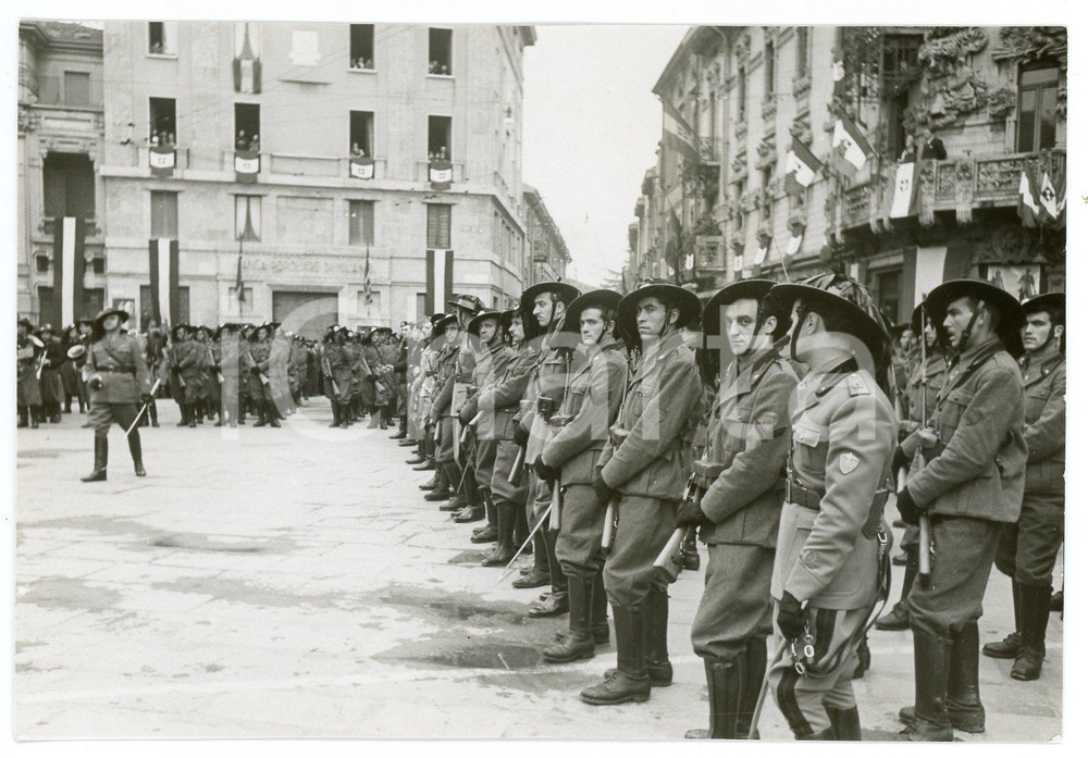 1939 BUSTO ARSIZIO Piazza Garibaldi BERSAGLIERI celebrazioni 24 maggio - Foto 1 Fotografia d'epoca in formato cartolina postale.Nella fotografia compaiono il Capitano Milani e i sottotenenti Toni, Amoroso e Partesi.FOTORAFO: Foto Novelli - Busto Arsizio(Rif. A247) CONDIZIONI:POOR/danneggiato Abrasioni e residuo di incollatura al verso, margini rifilatiFORMATO: 14x9 cm originale e autentica 1