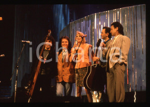 35mm vintage slide* 1990 Festival di SANREMO - POOH con Gabriella CARLUCCI (2)   Diapositiva d'epoca, in formato 35 mm.Nella diapositiva i componenti del gruppo musicale POOH (Roby Facchinetti, Dodi Battaglia, Stefano D'Orazio e Red Canzian) con Gabriella Carlucci sul palcoscenico del Festival di Sanremo del 1990. CONDIZIONI: GOODE' severamente vietata la riproduzione. Tutti i diritti sono riservati. ICharta mette in vendita, sul negozio eBay e in esclusiva sul sito "icharta" il proprio archivio composto da numerose diapositive e negativi fotografici d'epoca, tutti originali e autentici, che attraversano la storia del costume italiano tra gli la fine degli anni Sessanta e Novanta.Si tratta di uno sguardo inedito sull'attualit&agrave;, la politica, la vita quotidiana, il gossip e la cultura, che fotografa il cambiamento della nazione in quest'ultimo scorcio del XX secolo. Un'occasione unica per il mercato del collezionismo, che vede finalmente disponibile un archivio eccezionale per vastit&agrave;, tematiche e condizioni, in un settore (il negativo fotografico e la diapositiva) di assoluta novit&agrave; e dalle interessanti prospettive di investimento.  originale e autentica 1