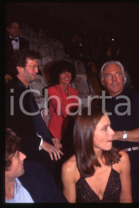 Giorgio ARMANI Eric CLAPTON Ornella MUTI - MODA 1995 ca * 35 mm vintage slide  Diapositiva d'epoca, in formato 35 mm.CONDIZIONI: GOODE' severamente vietata la riproduzione. Tutti i diritti sono riservati.ICharta mette in vendita, sul negozio eBay e in esclusiva sul sito "icharta" il proprio archivio composto da numerose diapositive e negativi fotografici d'epoca, tutti originali e autentici, che attraversano la storia del costume italiano tra gli la fine degli anni Sessanta e Novanta.Si tratta di uno sguardo inedito sull'attualità, la politica, la vita quotidiana, il gossip e la cultura, che fotografa il cambiamento della nazione in quest'ultimo scorcio del XX secolo. Un'occasione unica per il mercato del collezionismo, che vede finalmente disponibile un archivio eccezionale per vastità, tematiche e condizioni, in un settore (il negativo fotografico e la diapositiva) di assoluta novità e dalle interessanti prospettive di investimento.  GOOD/buono   originale e autentica 1