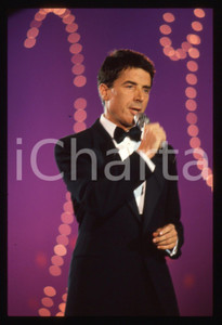 35mm vintage slide* 1989 CANALE 5 Don BACKY a C'era una volta il Festival (9)  Diapositiva d'epoca, in formato 35 mm. CONDIZIONI: GOODE' severamente vietata la riproduzione. Tutti i diritti sono riservati. ICharta mette in vendita, sul negozio eBay e in esclusiva sul sito "icharta" il proprio archivio composto da numerose diapositive e negativi fotografici d'epoca, tutti originali e autentici, che attraversano la storia del costume italiano tra gli la fine degli anni Sessanta e Novanta.Si tratta di uno sguardo inedito sull'attualit&agrave;, la politica, la vita quotidiana, il gossip e la cultura, che fotografa il cambiamento della nazione in quest'ultimo scorcio del XX secolo. Un'occasione unica per il mercato del collezionismo, che vede finalmente disponibile un archivio eccezionale per vastit&agrave;, tematiche e condizioni, in un settore (il negativo fotografico e la diapositiva) di assoluta novit&agrave; e dalle interessanti prospettive di investimento.  originale e autentica 1