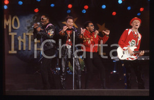 35mm vintage slide* 1991 SANREMO INTERNATIONAL George CHANDLER  LONDONBEAT 32 Nella diapositiva compaiono anche Jimmy Helms, William Henshall e Jimmy ChambersDiapositiva d'epoca, in formato 35 mm. CONDIZIONI: GOODE' severamente vietata la riproduzione. Tutti i diritti sono riservati. ICharta mette in vendita, sul negozio eBay e in esclusiva sul sito "icharta" il proprio archivio composto da numerose diapositive e negativi fotografici d'epoca, tutti originali e autentici, che attraversano la storia del costume italiano tra gli la fine degli anni Sessanta e Novanta.Si tratta di uno sguardo inedito sull'attualit&agrave;, la politica, la vita quotidiana, il gossip e la cultura, che fotografa il cambiamento della nazione in quest'ultimo scorcio del XX secolo. Un'occasione unica per il mercato del collezionismo, che vede finalmente disponibile un archivio eccezionale per vastit&agrave;, tematiche e condizioni, in un settore (il negativo fotografico e la diapositiva) di assoluta novit&agrave; e dalle interessanti prospettive di investimento.  originale e autentica 1