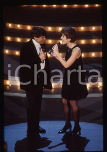 35mm vintage slide* 1995 SANREMO Gianni MORANDI e Barbara COLA all'Ariston (1) Diapositiva d'epoca, in formato 35 mm. CONDIZIONI: GOODE' severamente vietata la riproduzione. Tutti i diritti sono riservati.Nella diapositiva ICharta mette in vendita, sul negozio eBay e in esclusiva sul sito "icharta" il proprio archivio composto da numerose diapositive e negativi fotografici d'epoca, tutti originali e autentici, che attraversano la storia del costume italiano tra gli la fine degli anni Sessanta e Novanta.Si tratta di uno sguardo inedito sull'attualit&agrave;, la politica, la vita quotidiana, il gossip e la cultura, che fotografa il cambiamento della nazione in quest'ultimo scorcio del XX secolo. Un'occasione unica per il mercato del collezionismo, che vede finalmente disponibile un archivio eccezionale per vastit&agrave;, tematiche e condizioni, in un settore (il negativo fotografico e la diapositiva) di assoluta novit&agrave; e dalle interessanti prospettive di investimento.  originale e autentica 1