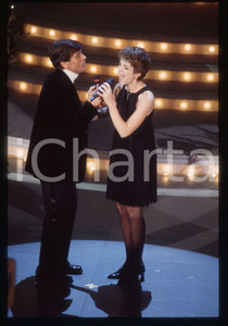 35mm vintage slide* 1995 SANREMO Gianni MORANDI e Barbara COLA all'Ariston (2) Diapositiva d'epoca, in formato 35 mm. CONDIZIONI: GOODE' severamente vietata la riproduzione. Tutti i diritti sono riservati.Nella diapositiva ICharta mette in vendita, sul negozio eBay e in esclusiva sul sito "icharta" il proprio archivio composto da numerose diapositive e negativi fotografici d'epoca, tutti originali e autentici, che attraversano la storia del costume italiano tra gli la fine degli anni Sessanta e Novanta.Si tratta di uno sguardo inedito sull'attualit&agrave;, la politica, la vita quotidiana, il gossip e la cultura, che fotografa il cambiamento della nazione in quest'ultimo scorcio del XX secolo. Un'occasione unica per il mercato del collezionismo, che vede finalmente disponibile un archivio eccezionale per vastit&agrave;, tematiche e condizioni, in un settore (il negativo fotografico e la diapositiva) di assoluta novit&agrave; e dalle interessanti prospettive di investimento.  originale e autentica 1