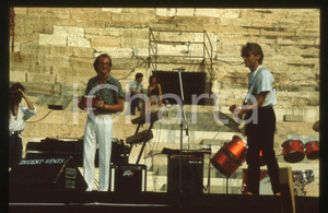 35mm vintage slide* 1983 ARENA VERONA John GULDBERG Tim STAHL dei LAID BACK Diapositiva d'epoca, in formato 35 mm. CONDIZIONI: GOODE' severamente vietata la riproduzione. Tutti i diritti sono riservati.Nella diapositiva ICharta mette in vendita, sul negozio eBay e in esclusiva sul sito "icharta" il proprio archivio composto da numerose diapositive e negativi fotografici d'epoca, tutti originali e autentici, che attraversano la storia del costume italiano tra gli la fine degli anni Sessanta e Novanta.Si tratta di uno sguardo inedito sull'attualit&agrave;, la politica, la vita quotidiana, il gossip e la cultura, che fotografa il cambiamento della nazione in quest'ultimo scorcio del XX secolo. Un'occasione unica per il mercato del collezionismo, che vede finalmente disponibile un archivio eccezionale per vastit&agrave;, tematiche e condizioni, in un settore (il negativo fotografico e la diapositiva) di assoluta novit&agrave; e dalle interessanti prospettive di investimento.  originale e autentica 1